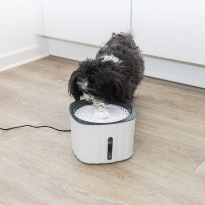 Dispensador de água para animais em plástico branco com detalhes cinzentos no chão