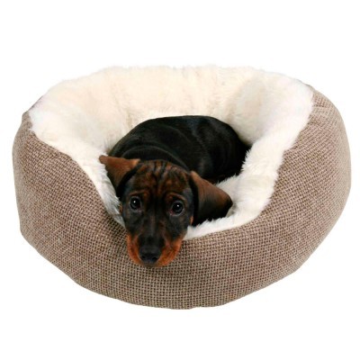 Cama para cão redonda bege com interior branco felpudo e um cão pequeno preto e castanho deitado