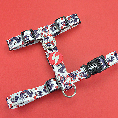 Arnês para cães branco com padrão de rostos de cães sobre fundo vermelho