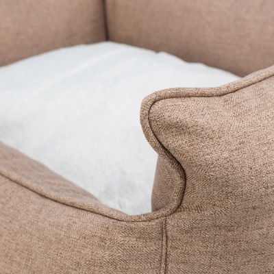 Cama para cachorro castanha com almofada branca num canto