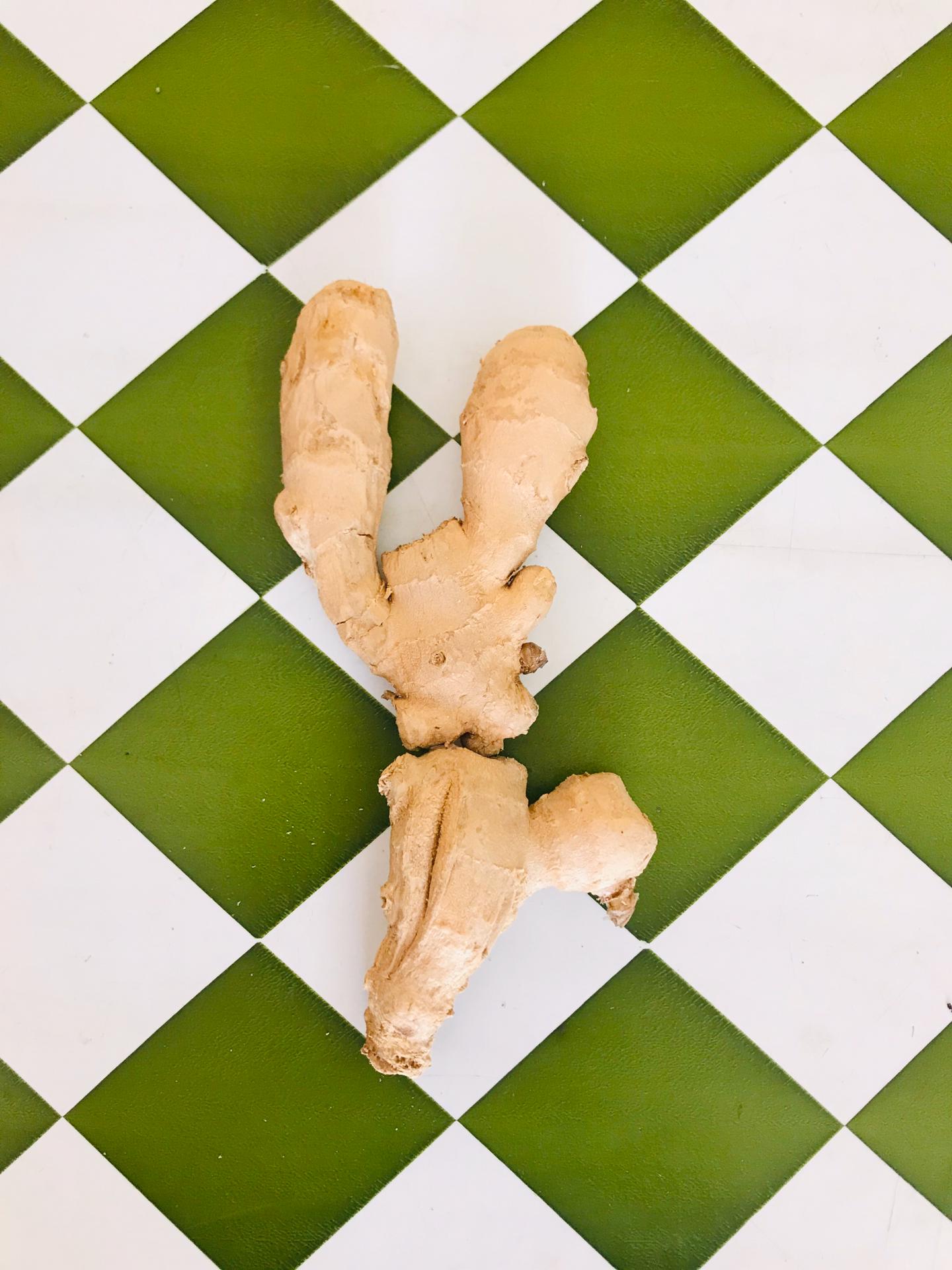 Gengibre da horta do Ti Xico (kg) Raiz de gengibre sobre azulejos verdes e brancos em padrão xadrez