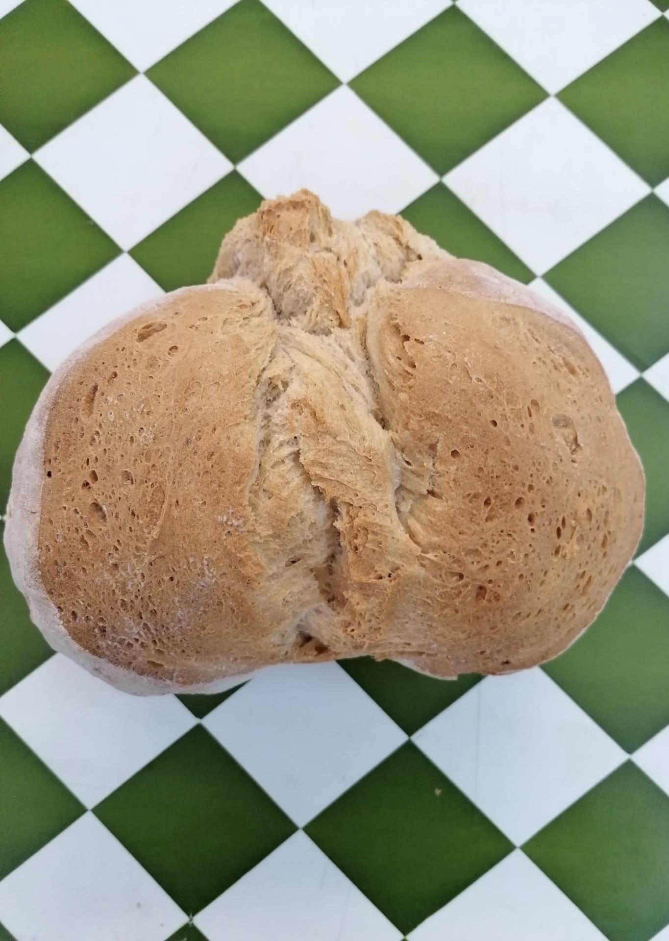 Pão Alentejano Trigo Pão caseiro sobre azulejos verdes e brancos em padrão xadrez