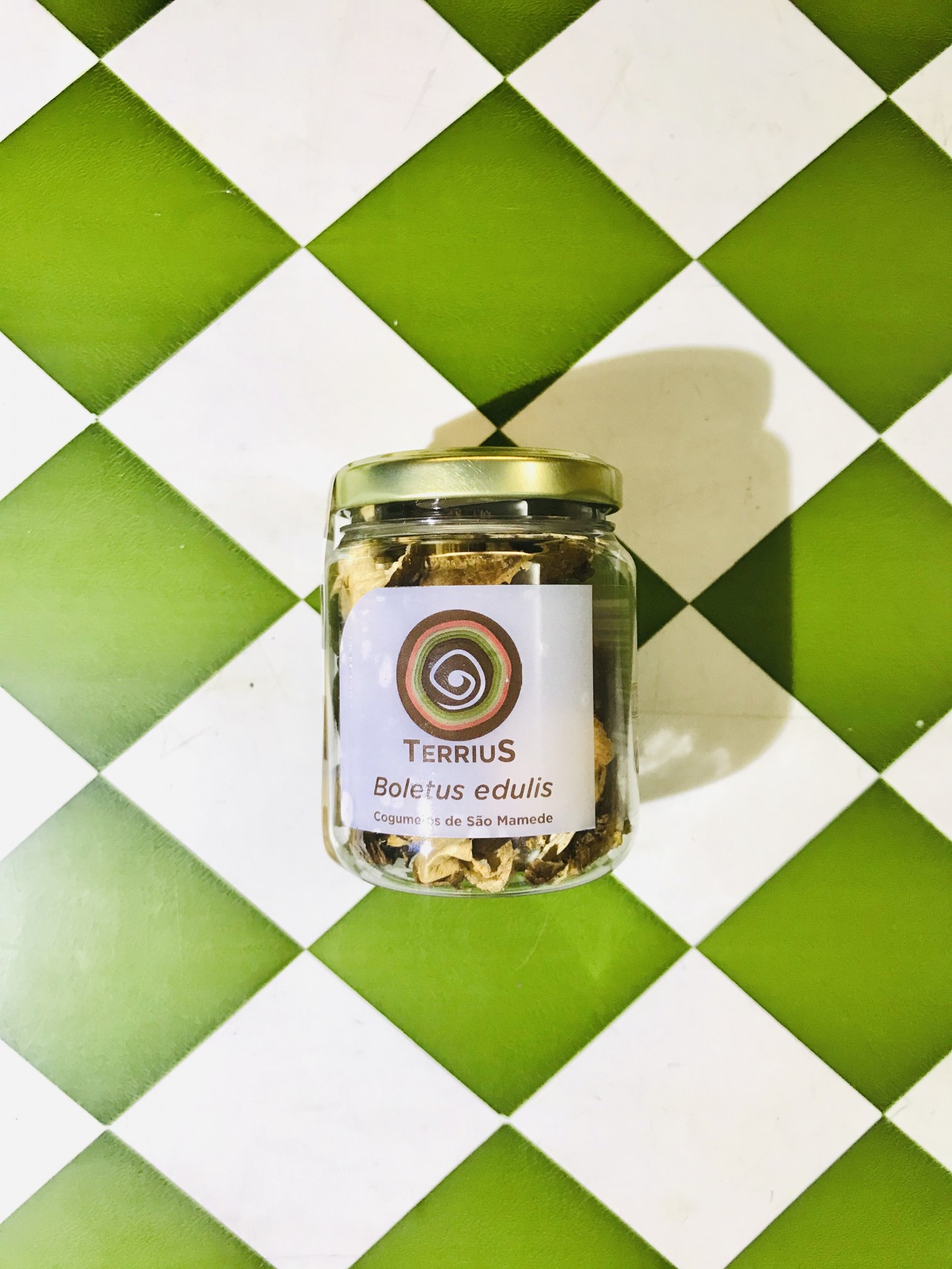 Cogumelos boletus 15g Frasco de vidro com cogumelos secos sobre azulejos verdes e brancos