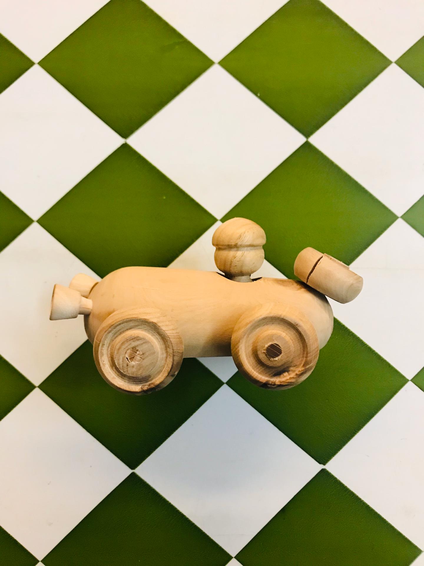 Carrinho de madeira oliveira Brinquedo de madeira em forma de veículo sobre azulejos verdes e brancos