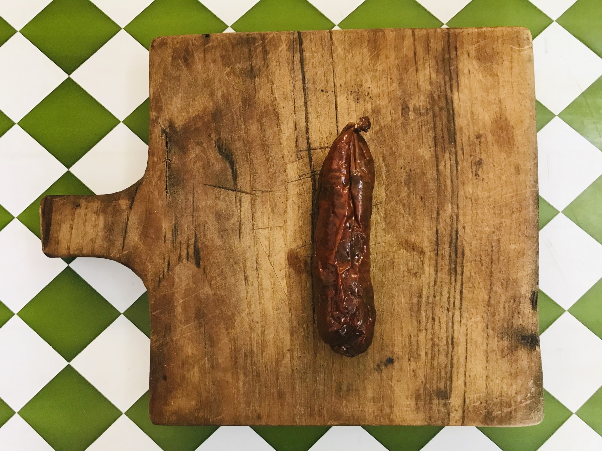 Paio de Porco Preto Tábua de madeira quadrada com enchido seco sobre fundo de azulejos verdes e brancos
