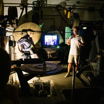 Oficina industrial com máquinas e pessoas em ambiente escuro