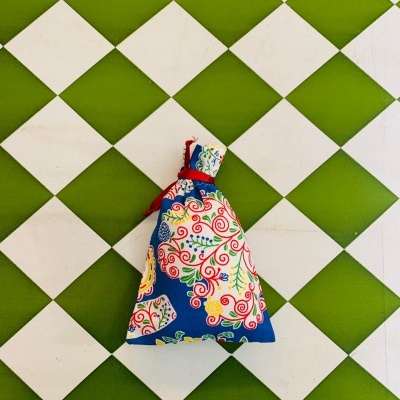 Saco de tecido colorido em pavimento quadriculado verde e branco