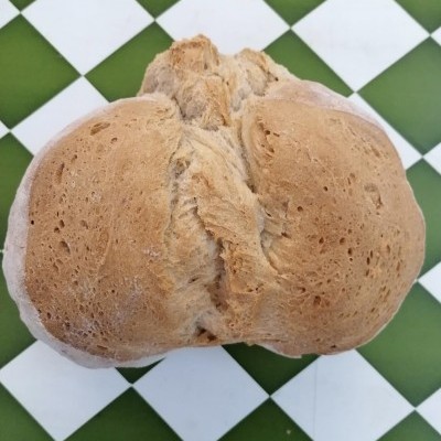 Pão caseiro sobre azulejos verdes e brancos em padrão xadrez