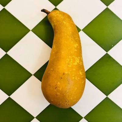 Pera amarela com manchas numa superfície quadriculada verde e branca