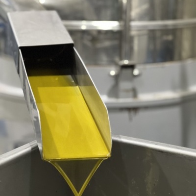 Máquina a verter líquido amarelo-esverdeado em recipiente metálico