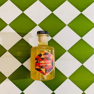 Garrafa pequena de licor com rótulo em fundo xadrez verde e branco