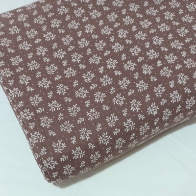 Musselina com raminhos brancos em fundo castanho