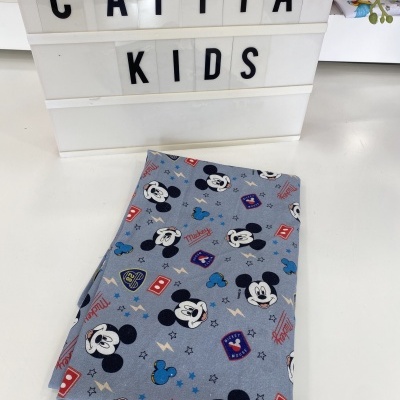 Pano infantil de tecido cinza com padrão de Mickey Mouse e placa luminosa com texto Catita Kids
