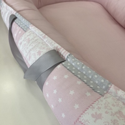Berço portátil rosa e cinza com padrão patchwork e alças cinza