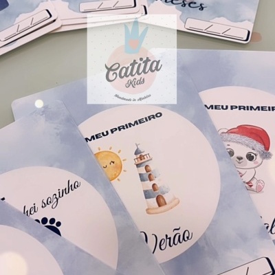 Cartões de marcos do bebé com ilustrações infantis e números em azul sobre fundo azul claro.