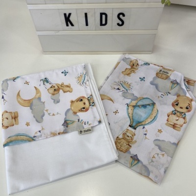 Toalhas infantis estampadas com ursos, balões e estrelas sobre fundo branco ao lado de placa com texto CATITA KIDS