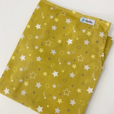 Tecido amarelo com padrão de estrelas e etiqueta Taíta