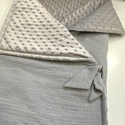 Saco de bebé cinza claro com padrão dourado e interior com textura de bolinhas