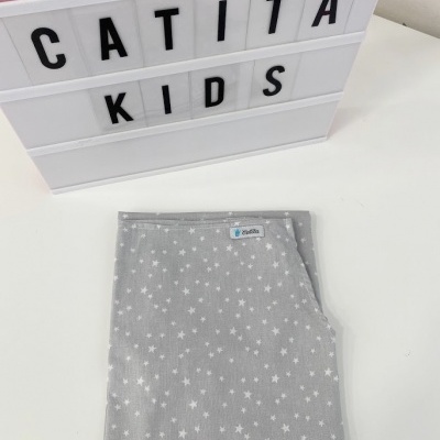 Lençol cinzento para crianças com estrelas brancas dobrado sobre superfície branca com caixa de luz 'CATITA KIDS'