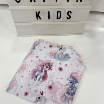 T-shirt dobrada estampada com unicórnios e cisnes junto a painel luminoso CATITA KIDS