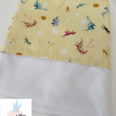 Fralda de pano branca com barra estampada de dinossauros em várias cores.