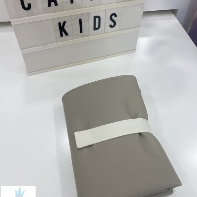 Caderno cinzento com faixa branca em superfície branca e letreiro 'CATITA KIDS'