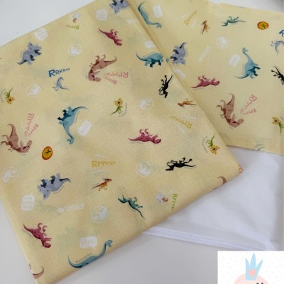 Tecido amarelo com padrão de dinossauros coloridos e frases, com logo Catita Kids ao lado