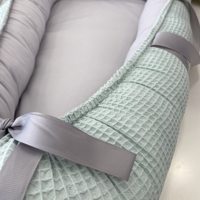 Ninho de bebé cinza claro com textura e fita de ajuste cinza