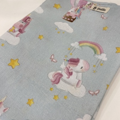 tecido azul claro com padrão de unicórnios e estrelas