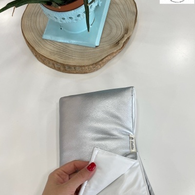 tecido prateado brilhante com etiqueta Catita Kids sobre mesa branca com planta em vaso azul