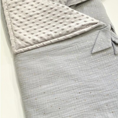 Manta ou saco de bebê cinzento claro com padrão de pontos dourados e interior cinzento claro texturado.