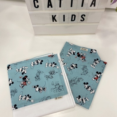 Toalha e babete com padrão Disney Mickey Mouse azul claro sobre mesa branca com caixa de letras CATITA KIDS