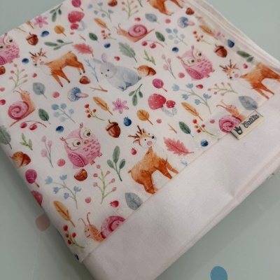 Fralda branca com padrão colorido de animais da floresta e etiqueta Catita