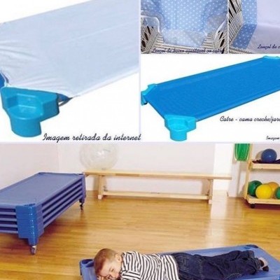 Colchão infantil azul com criança a dormir no chão de madeira e ambiente de ginásio ao fundo