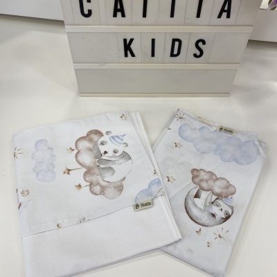 Tecidos infantis brancos com estampas de nuvens e animais, etiqueta 'La Bastide' e placa luminosa 'CATITA KIDS'