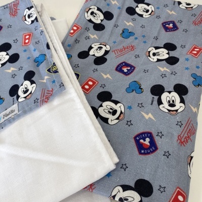 Tecidos branco e azul com estampas da personagem Mickey Mouse