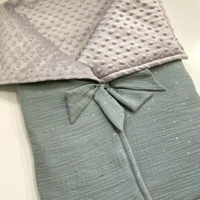 Cobertor macio para bebé em algodão cinzento com laço e interior cinza com relevo de bolinhas.