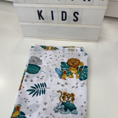 Pano de tecido com motivos de animais para crianças sobre superfície branca e caixa de luz com texto CATITA KIDS