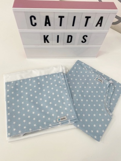 Cobertor e pijama azul claro com estrelas brancas ao lado de caixa luminosa com texto CATITA KIDS