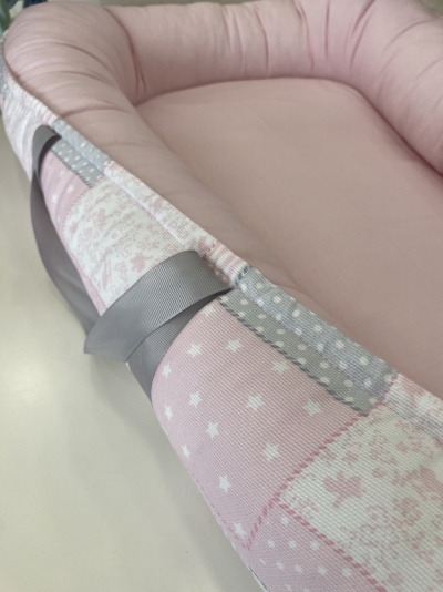 Berço portátil rosa e cinza com padrão patchwork e alças cinza