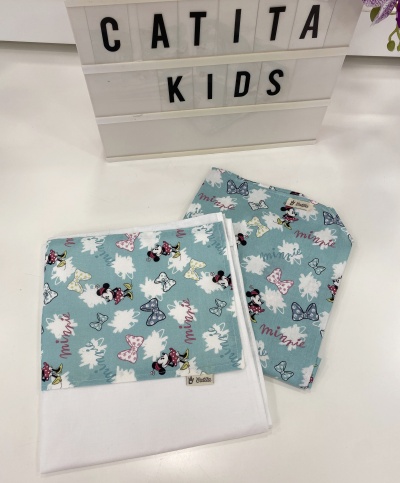 Toalha e babete com padrão Minnie Mouse em azul claro sobre mesa branca