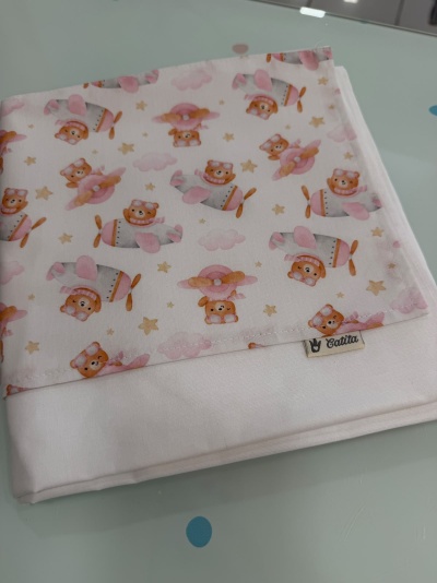 Fralda estampada com ursinhos e aviões em rosa sobre fundo branco
