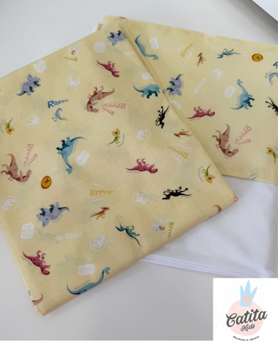 Tecido amarelo com padrão de dinossauros coloridos e frases, com logo Catita Kids ao lado