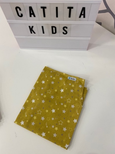 Lenço amarelo com padrão de estrelas sobre superfície branca com placa 'CATITA KIDS'