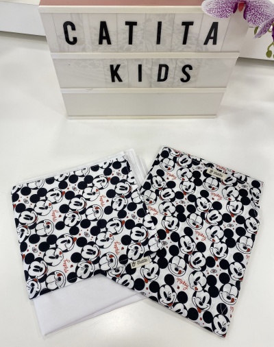 Tecidos com padrão Mickey Mouse em preto, branco e vermelho, caixa de luz com texto 'CATITA KIDS' e orquídea lilás.