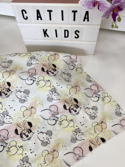 Tecido branco com padrão de Minnie Mouse em preto, amarelo e rosa junto a placa luminosa 'CATITA KIDS'