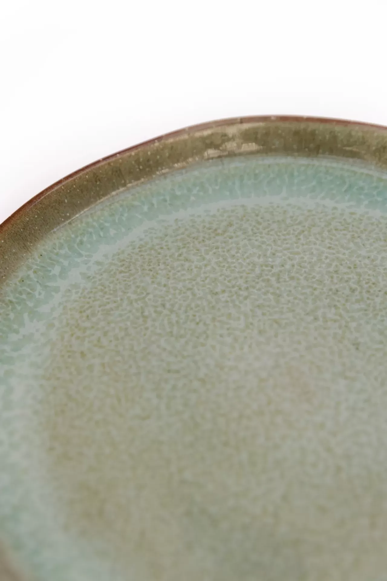 Prato redondo de cerâmica verde com borda castanha e textura esmaltada