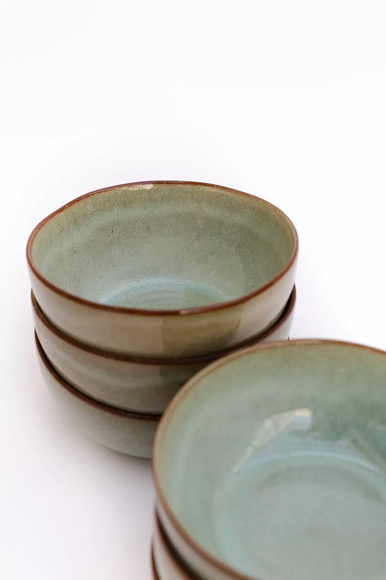 Tigelas de cerâmica azul claro com borda castanha empilhadas