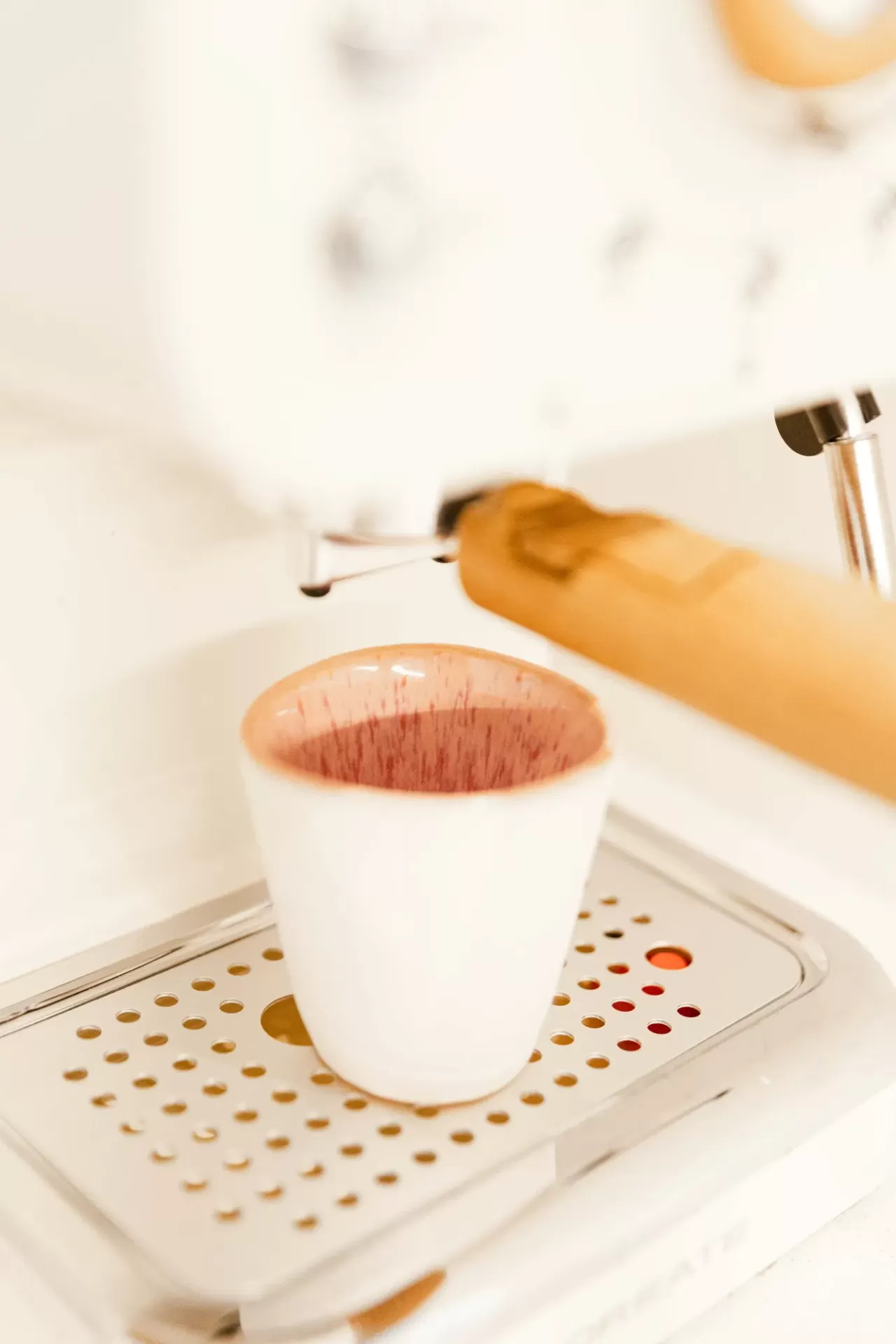 Máquina de café expresso branca com chávena e braço de porta-filtro em madeira