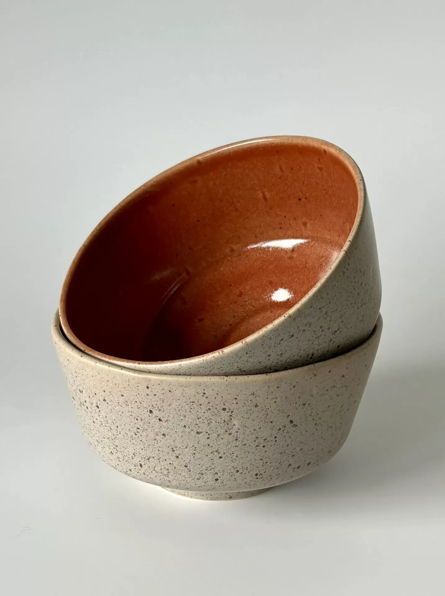 Pratos de cerâmica cinza com interior laranja empilhados